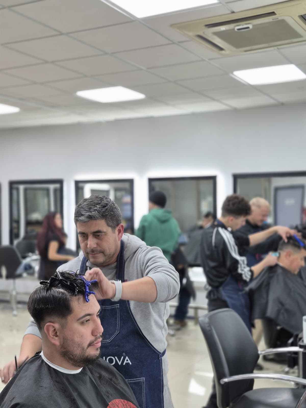 Alumno en práctica seccionando cabello para un corte preciso - Curso de Barbería Esencial - Innova