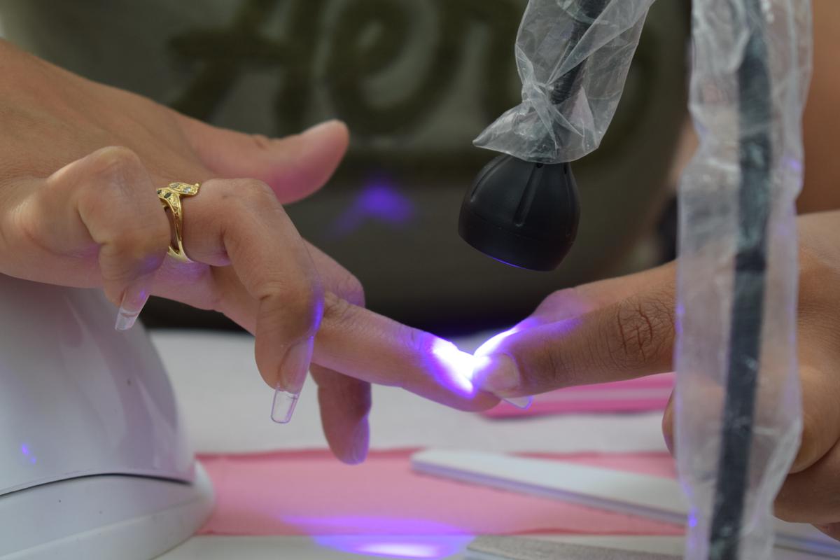Adhesión del tips con luz ultravioleta manual para fijación inicial - Curso de Manicure Spa mención uñas Softgel y Polygel - Innova