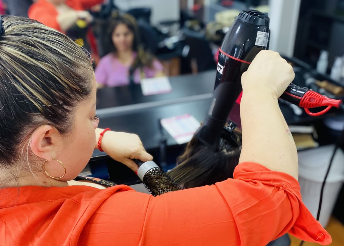 Aplicación técnica de brushing en cabello de modelo por alumna. - Curso de Peluquería - Innova
