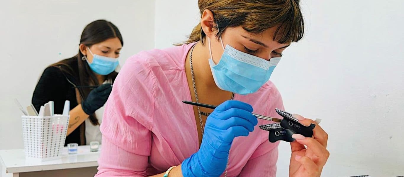 Alumnas del curso de manicura trabajando sobre molde