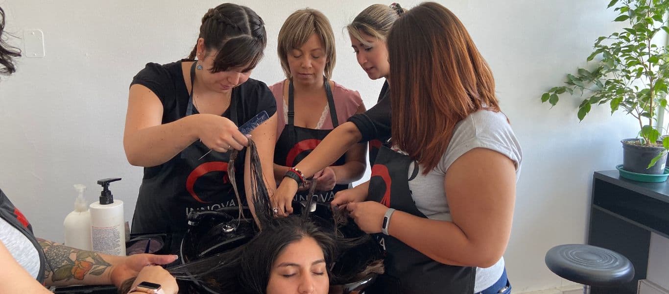 Alumnas de curso de peluquería realizando práctica