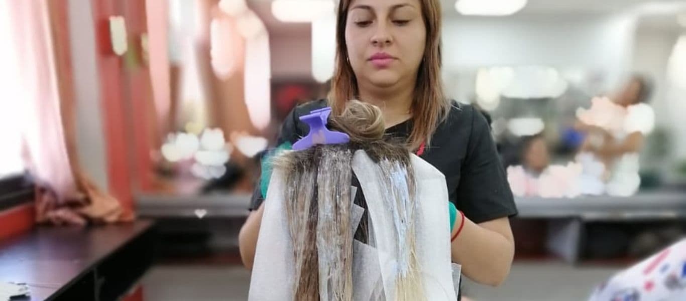 Alumna de curso de peluquería realizando práctica