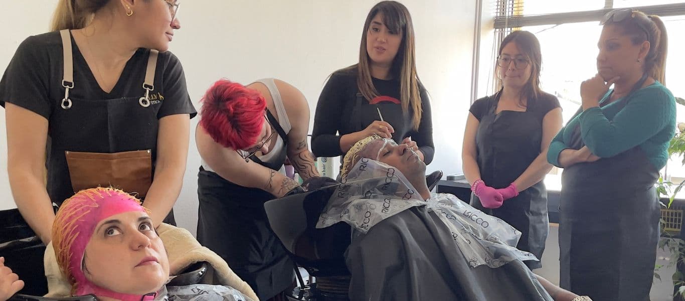 Alumnas del curso de peluquería realizando visos sobre modelos